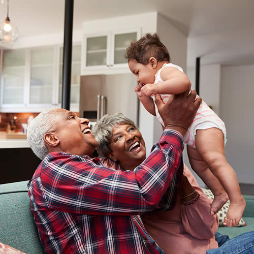 Couple on couch with their grandchild.