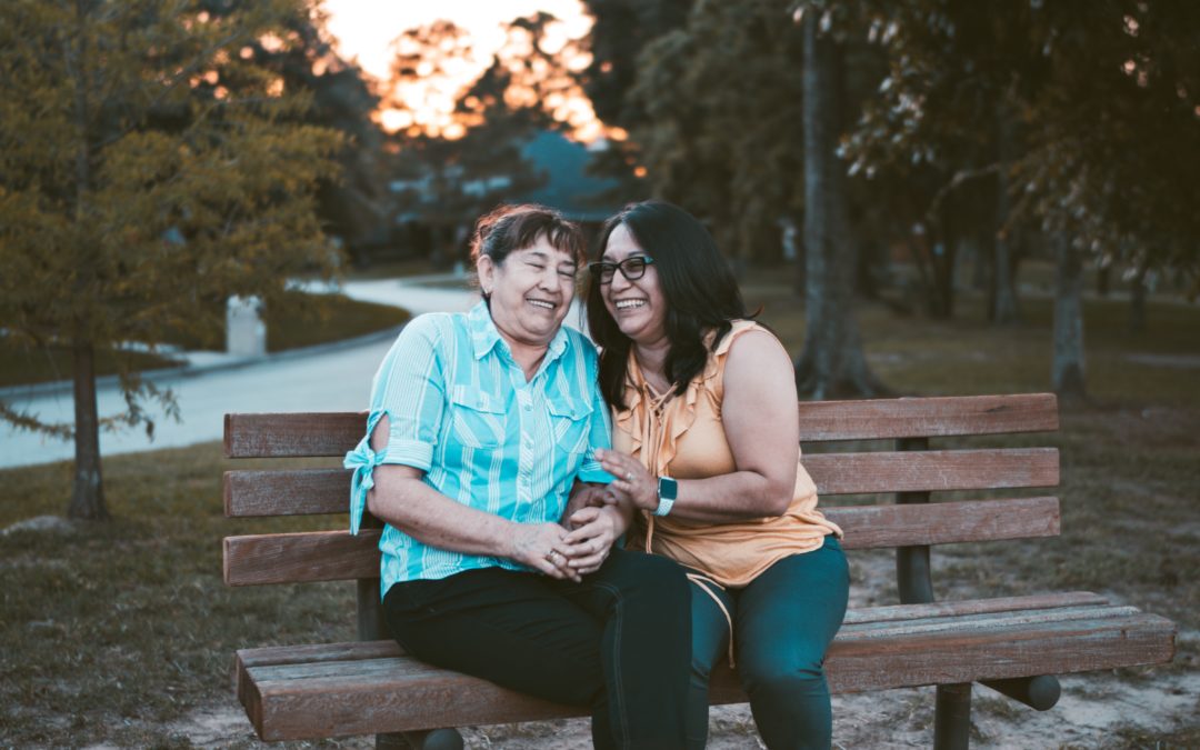 A mother and daughter talking on a bench